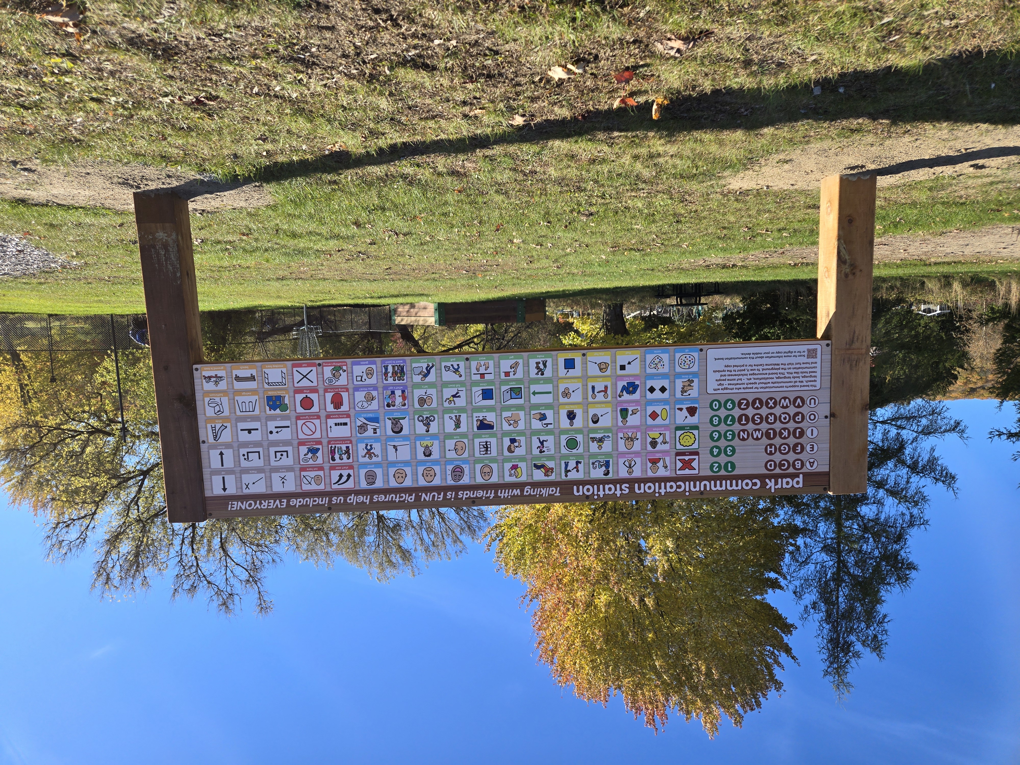 An alternative and augmentative (symbols) communication board outside in a park.